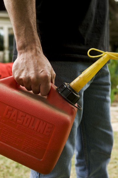 Hand holding gas can. Photographe : Stewart Cohen