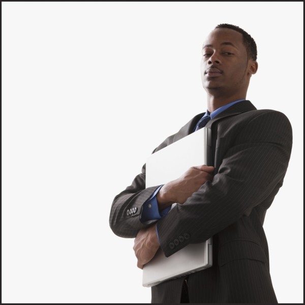 Serious businessman holding a laptop computer. Photographe : Mike Kemp