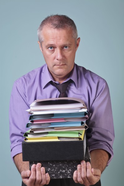 Man holding a stack of paper work. Photographe : RTimages