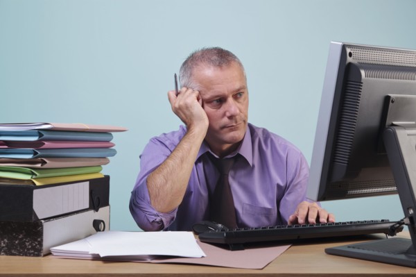 Overworked man sitting at his desk. Photographe : RTimages