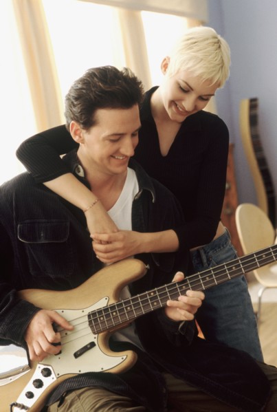 Woman listening to her boyfriend playing the electric bass. Photographe : Rob Lewine