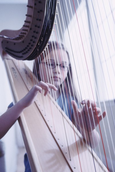 Young girl playing the harp. Photographe : Rob Lewine