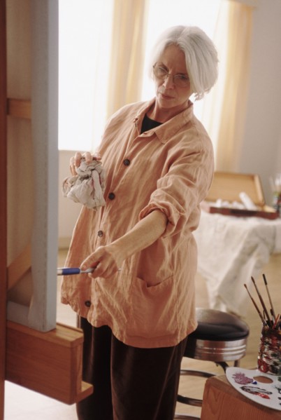 Elderly woman painting on a canvass. Photographe : Rob Lewine