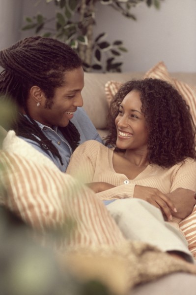 Couple relaxing together on the couch. Photographe : Rob Lewine