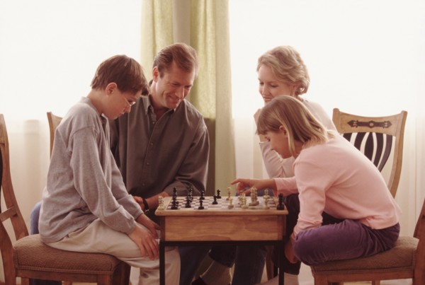 Family playing chess together. Photographe : Rob Lewine