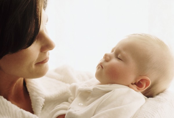 Mother holding her sleeping baby. Photographe : Rob Lewine