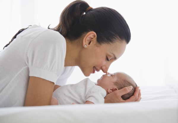 Mother gazing at her sleeping baby.