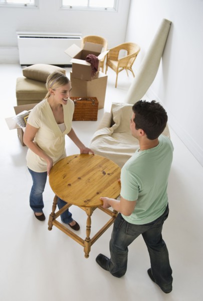 Couple moving furniture in their new home.