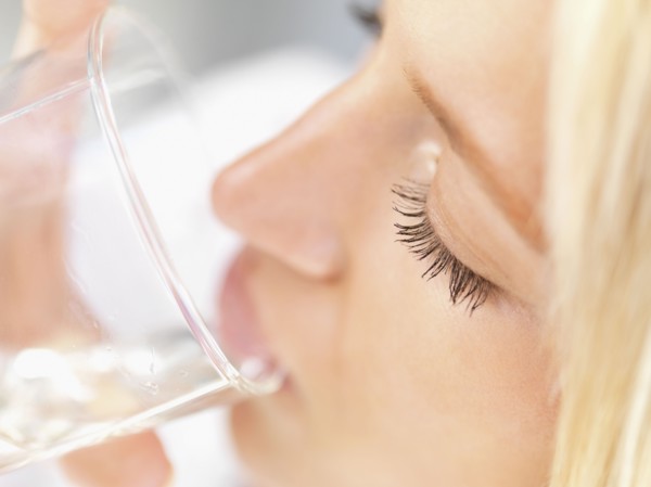 Woman drinking a glass of water. Photo : momentimages