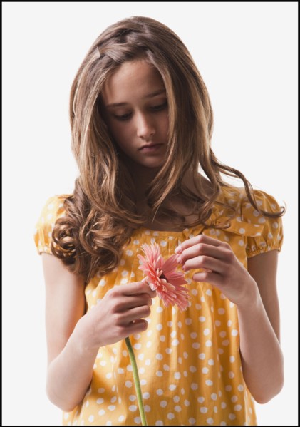 Teenage girl picking petals off of a flower. Photo : Mike Kemp