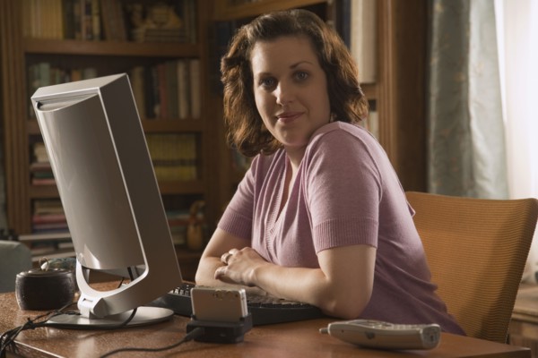 Woman sitting at desk in home office. Photo : Stewart Cohen