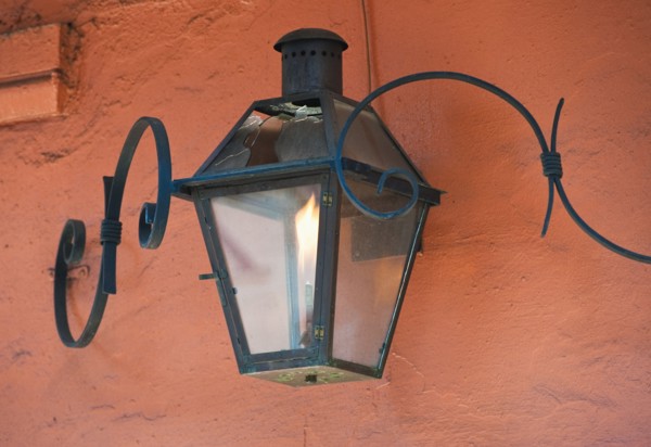 Lantern on an orange stucco wall.