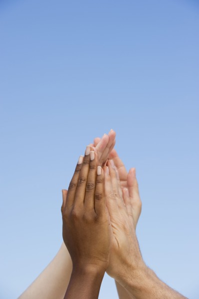 Four hands reaching up.