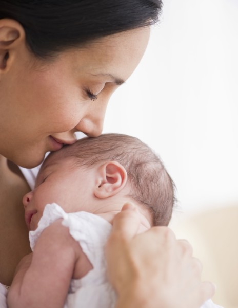 Mother kissing her baby's head.