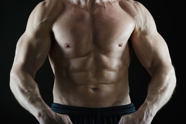 Muscular man flexing his muscles. Photo : Daniel Grill