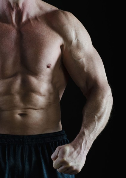 Muscular man flexing his muscles. Photo : Daniel Grill