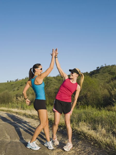 Two trail runners giving each other a high five.