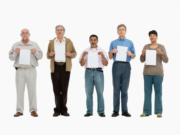 Group of people standing in a row holding papers. Photo : momentimages