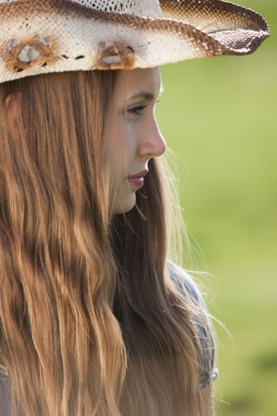 Side profile of a beautiful long haired cowgirl. Photo : Mike Kemp
