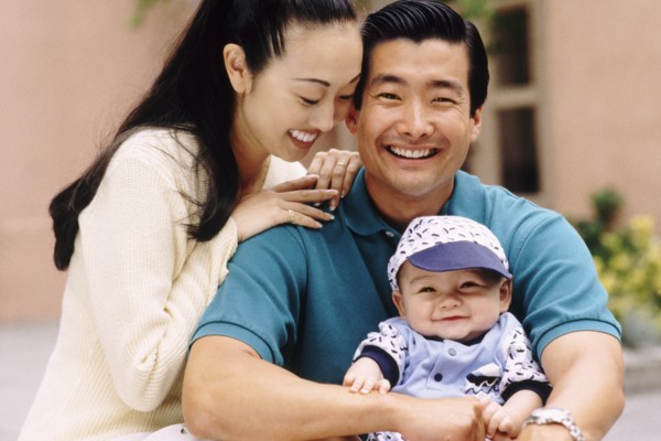 Happy parents sitting with their infant son. Photo : Rob Lewine