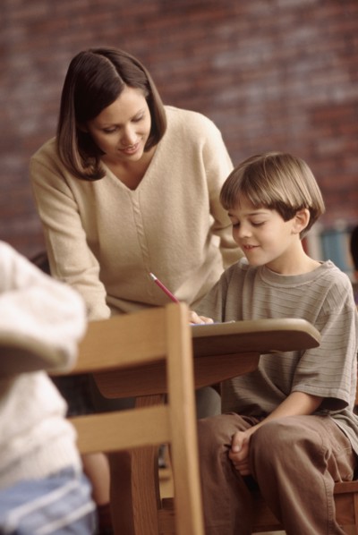 Teacher talking to elementary school student. Photo : Rob Lewine