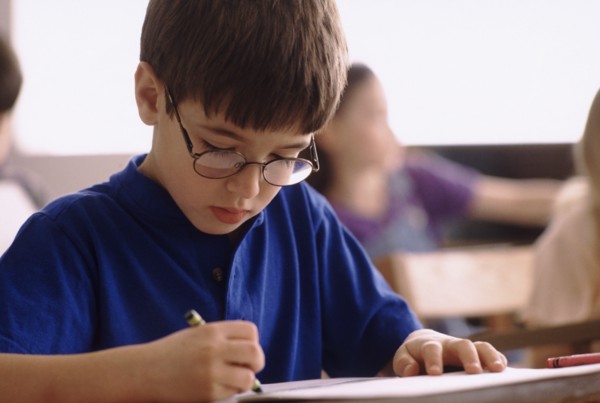 Elementary school student coloring with crayon. Photo : Rob Lewine