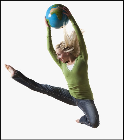 Woman jumping in air while holding globe. Photo : Mike Kemp