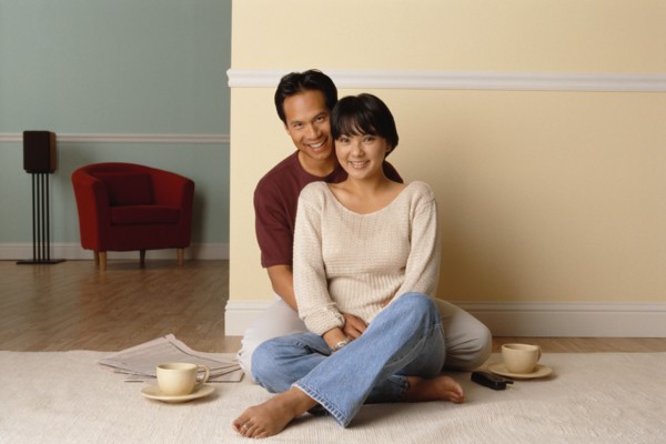 Happy couple sitting together on the floor in their home. Photo : Rob Lewine