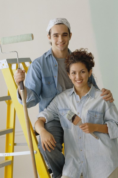 Happy couple painting the walls in their home. Photo : Rob Lewine