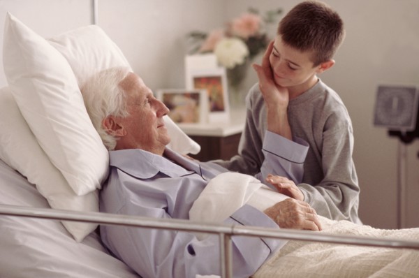 Grandson visiting Grandfather in hospital. Photo : Rob Lewine