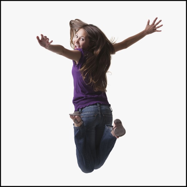 Teenage girl jumping for joy. Photo : Mike Kemp