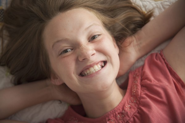 Young girl making cheesy smile. Photo : Mike Kemp