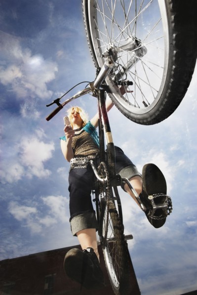 Teenage girl doing a bike trick. Photo : Stewart Cohen