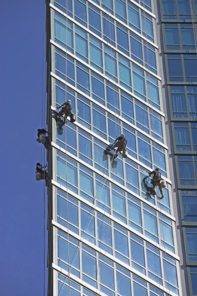 Window washers cleaning windows on skyscraper. Photo : fotog
