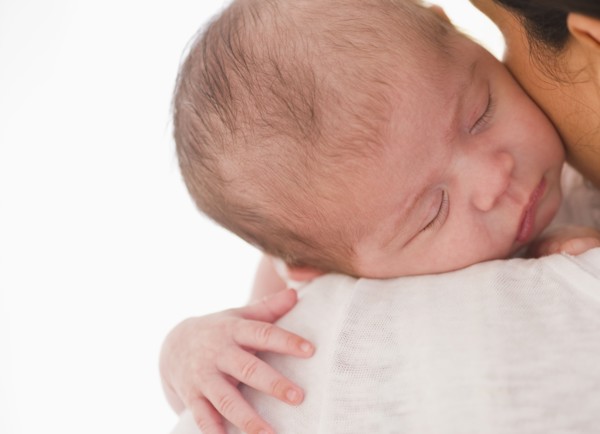 Baby sleeping on mother's shoulder.