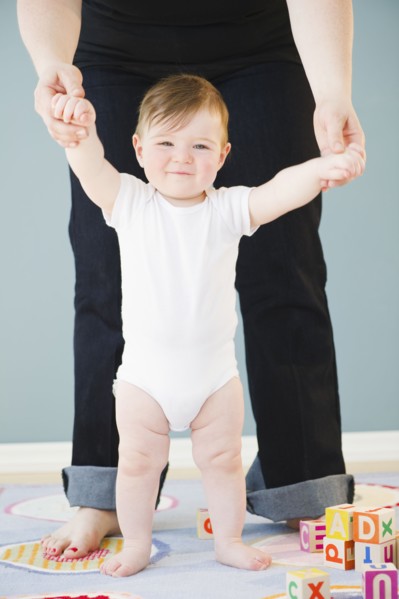 Toddler holding onto mother's hands. Photo : Jamie Grill