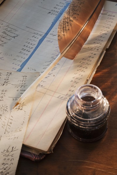 Ink feather pen and ledger.