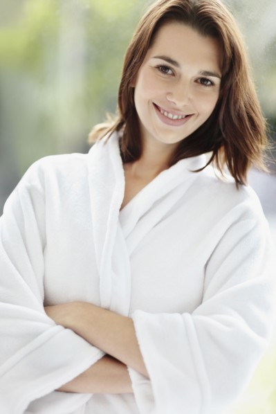 Smiling brunette woman wearing a bathrobe. Photo. momentimages