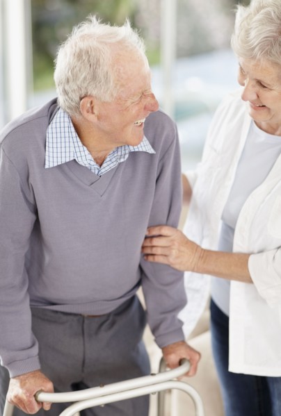 Senior woman assisting man with a walker. Photo. momentimages