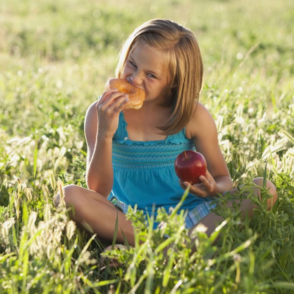 Young girl eating a doughnut. Photo. Mike Kemp