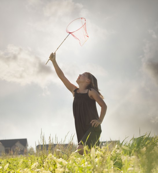 Young girl running with a butterfly net. Photo : Mike Kemp