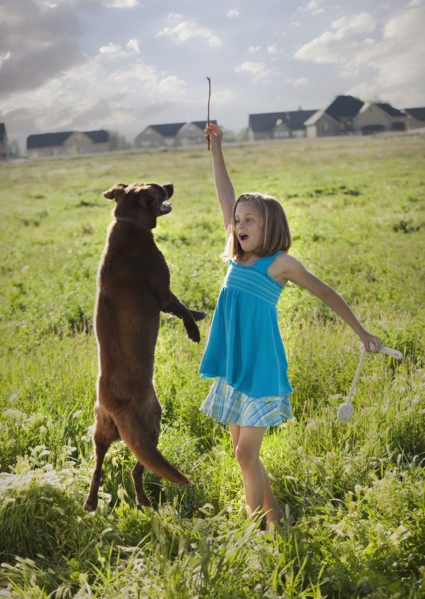 Young girl playing with her dog. Photo. Mike Kemp
