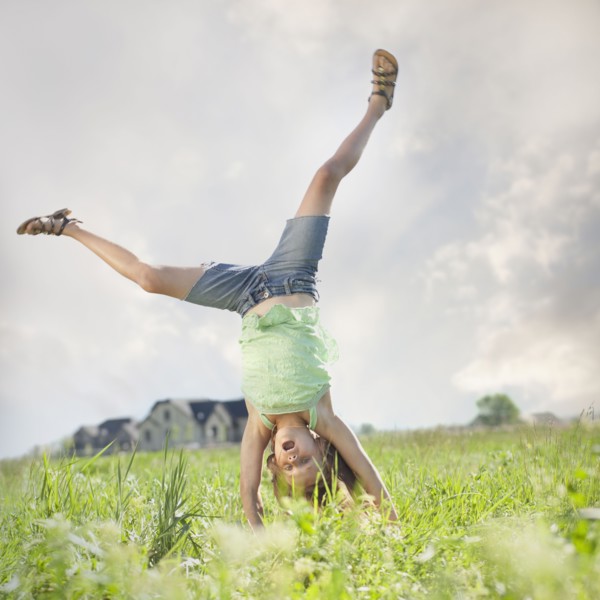 Young girl doing cartwheel. Photo : Mike Kemp