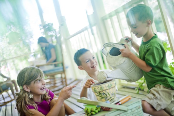Young children watering seeds in a planter. Photo : Tim Pannell