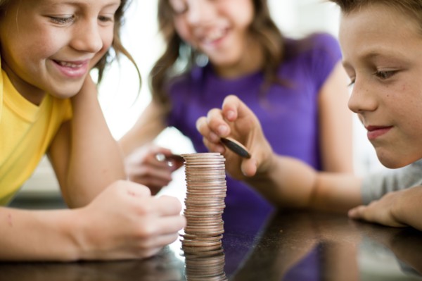 Children stacking coins. Photo : Tim Pannell