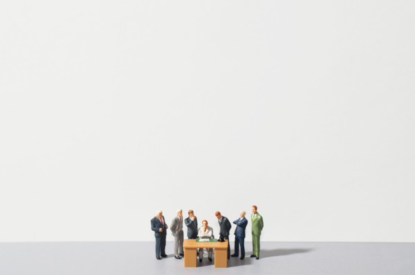Figurines of people standing around desk. Photo : Antonio M. Rosario