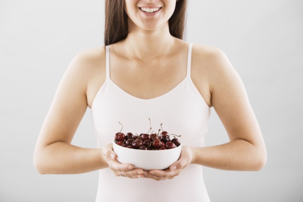 Woman holding a bowl of cherries. Photo : FBP