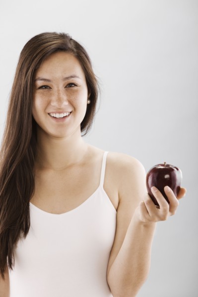 Woman holding a red apple. Photo : FBP