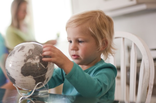 Young girl looking at globe. Photo : Tim Pannell