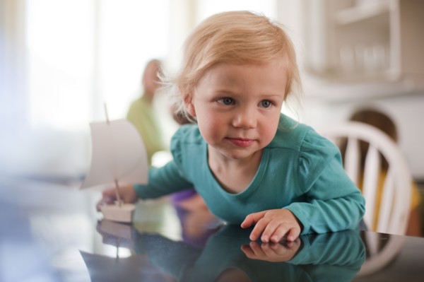 Young girl playing with toy boat. Photo : Tim Pannell